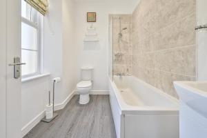 托基The Falstone Apartment的浴室配有卫生间、浴缸和水槽。