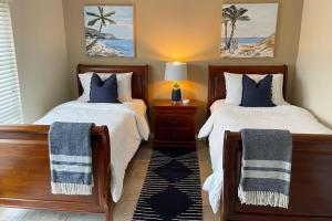 圣徒皮特海滩Dockside Destiny的一间卧室配有两张床和一张带台灯的桌子