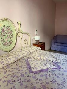 斯特雷萨达吉西旅馆的一间卧室配有一张带花卉床罩的床