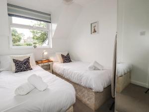 帕兹托Padstowgetaways的一间卧室设有两张单人床和一个窗户。