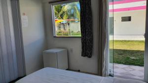 盖比姆Pousada Sol Nascente的客房设有窗户、床和窗户。