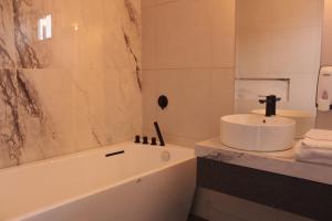 瓜亚基尔DC Suites Aeropuerto的浴室配有盥洗盆和浴缸。