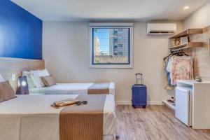 马塞约普拉亚旅馆的酒店客房设有两张床和窗户。