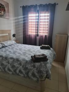 格拉纳迪利亚德亚沃纳Las Brisas的一间卧室配有床和带窗帘的窗户