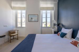 波尔多Les Séraphines - Chambres d'hôtes - Guests house的一间卧室设有一张大床和两个窗户。