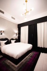 安曼Hotel Philosophy的一间卧室配有一张大床和黑色床头板