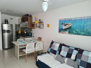塔曼达雷Apartamento Beira mar Praia dos Caneiros的带沙发和桌子的客厅以及厨房。