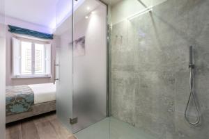 西尼加利亚La Romantica camere e wellness的一间带玻璃淋浴间和床的浴室