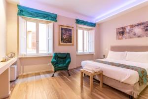 西尼加利亚La Romantica camere e wellness的一间卧室配有一张床和一把绿色椅子