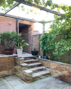 雷丁Corbridge Road的一个带砖墙和盆栽楼梯的庭院