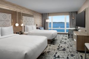 塔科马Silver Cloud Hotel Tacoma at Point Ruston Waterfront的酒店客房设有两张床和大窗户。