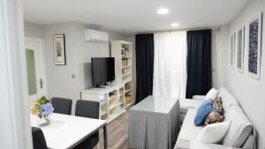 哈恩Slappe Jaén I的客厅配有白色沙发和电视