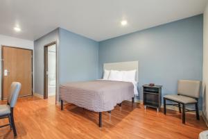 查尔斯顿Extended Stay America Select Suites - Charleston - North Charleston - I-526的卧室配有1张床、1张桌子和1把椅子