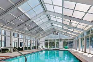 马纳萨斯马纳萨斯温德姆花园酒店的一个带玻璃天花板和窗户的室内游泳池