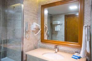 巴统巴统温德姆酒店的一间带水槽、淋浴和镜子的浴室
