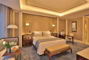 青岛青岛鑫江温德姆酒店的酒店客房设有一张大床和一张沙发。