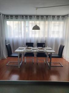 卡拉德费斯特拉特Sunny apartment Benidorm的餐桌、椅子和大窗户