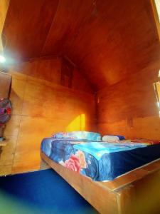 珀尼达岛鲁玛博宏山间小屋的木墙客房内的小床