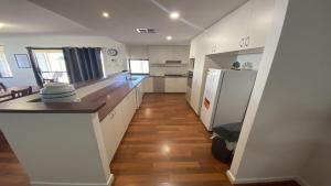 朱里恩湾Maniki Gardens的厨房铺有木地板,配有白色橱柜。