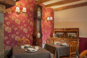 萨拉尔杜德特派斯酒店的一间设有两张桌子和外婆钟的餐厅