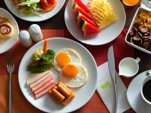 曼谷宜必思曼谷暹罗酒店 的餐桌上摆放着早餐盘,包括鸡蛋和蔬菜