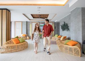 芭东海滩SKYVIEW Resort Phuket Patong Beach的男人和女人在客厅里走来走去