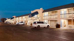 萨利纳南萨利纳戴斯酒店的两辆汽车停在大楼前的停车场