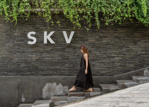 芭东海滩SKYVIEW Resort Phuket Patong Beach的一位女士在砖墙前走下几级楼梯