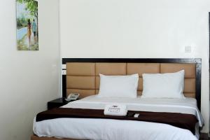 拉各斯Mariners Suites Lagos的一间卧室配有一张大床和棕色床头板