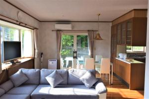 壹岐市ritomaru house iki ashibe的带沙发的客厅和厨房
