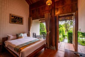富国Maison Du VietNam Resort & Spa的一间卧室设有一张床,并有通往庭院的门