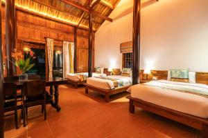 富国Maison Du VietNam Resort & Spa的一间卧室配有两张床和一张书桌。