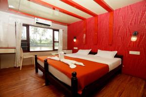 阿勒皮JCT Houseboat的卧室设有红色墙壁、一张床和一个窗户