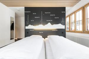 格施塔德博蒂赫莱斯酒店的墙上有黑板的房间,设有两张床