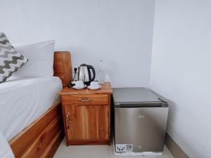 蓝梦岛极光海滩景旅馆的客房设有一张床和一张小桌子及冰箱