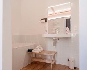 列日La Maison de Chestret的一间带水槽、浴缸和镜子的浴室