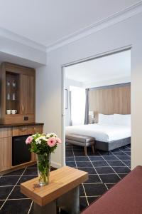 悉尼达令港假日酒店的一间酒店客房,配有一张床和一张桌子上的花瓶