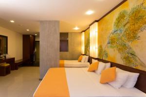 康提黄宝石酒店的酒店客房设有两张床,墙上挂有绘画作品