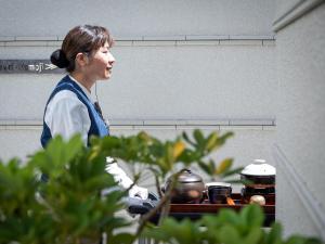 那霸Okinawa EXES Naha的站在厨房里,有锅碗瓢盆的女人