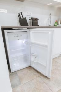 雅典Your Cozy Sapphire Apartment的厨房里设有白色冰箱,门开