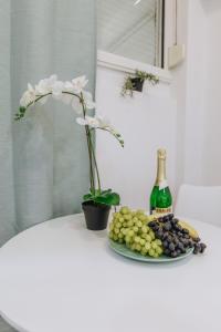 雅典Your Cozy Sapphire Apartment的一张桌子,上面放着一盘葡萄和一瓶葡萄酒