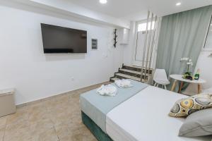 雅典Your Cozy Sapphire Apartment的配有一张床和一台平面电视的酒店客房