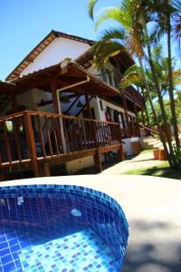 帕拉蒂Planeta Banana Paraty的房屋前方的蓝色瓷砖游泳池