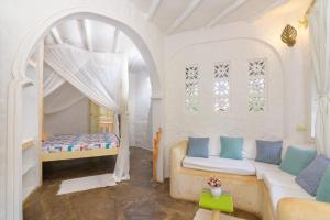 马林迪Peponi Villa Malindi的配有床和沙发的房间