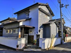 松山shiokaze guest house / Vacation STAY 6794的蓝色和白色的房子,前面有消防栓