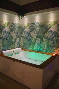 卡塔尼亚Terra Mia Suite的墙上的浴缸,上面有棕榈树壁画