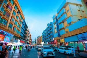 迪拜AL KARNAK HOTEL - BRANCH的一条繁忙的城市街道,街道上有很多汽车和人,建筑
