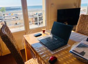 滨海布洛涅"BELLEVUE" Magnifique appartement vue sur mer et face à Nausicàa的一张桌子上的笔记本电脑,享有海景