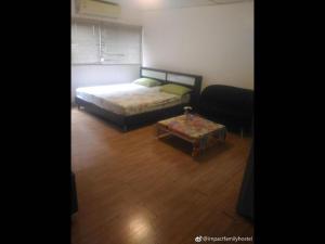 Thung Si KanThailand Taxi Apartment Hostel的一间卧室配有一张床和一张茶几