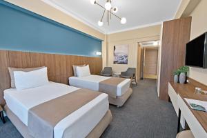 马马亚Hotel Oxford的酒店客房设有两张床和一台平面电视。